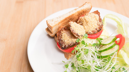 Vegan sandwich for breakfast, healthy & delicious food for plant based, vegan and vegetarian diet. Ingredients are toasted bread, vegan cheese, fried tofu, tomato, iceberg lettuce and kaiware sprouts.