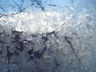 Texture of frosty patterns. Winter frosty patterns on the glass. New Year and Christmas abstract icy snowy background with real ice crystals macro in cold blue tones. Natural Snowflakes. Soft focus