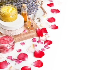 Spa and bath cosmetics. Scrub of different colors, aromatic oil, a white towel, a bouquet of...