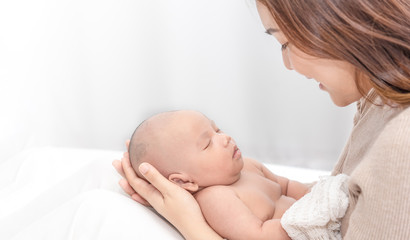 Close up beautiful young asian mother holding her newborn one month baby sleep on her arms. Healthcare and medical love asia woman lifestyle mother's day concept.