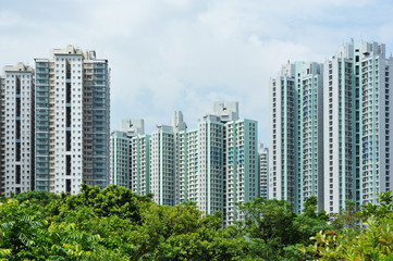 High-rise Residential Apartment Buildings under Cloudy Sky with Trees as Foreground in Tian Shui Wai Town, Yuen Long District, Hong Kong in July 2016