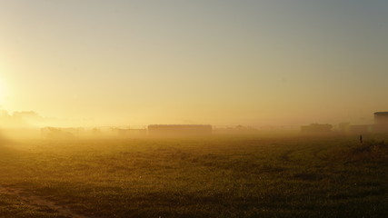 colorful summer morning with golden light and fog between hills