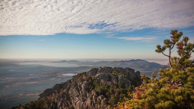 Epic view from the highest point of Sinyuha Mountain in autumn season in Burabay, Kazakhstan. Approach of the cyclone, the movement of low clouds over the forest; time lapse zoom out