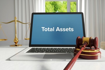 Total Assets – Law, Judgment, Web. Laptop in the office with term on the screen. Hammer, Libra, Lawyer.