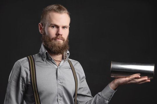 Handsome young man presents car parts on a gray background. The concept of sales and testing of goods