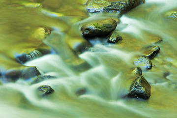 Little River rapids captured with motion blur and illuminated by reflected color from sunlit spring foliage, Great Smoky Mountains National Park, Tennessee, USA 