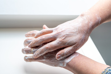 Fototapeta premium Woman washing her hands to avoid diseases like coronavirus