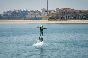 Water extreme sport. The guy is flying at the aquatic flyboard. Extreme rest on the sea