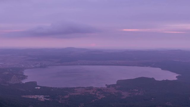 Sunrise view from the highest point of Sinyuha Mountain in autumn season in Burabay, Kazakhstan. Ripples in the water, approach of the cyclone; time lapse zoom in