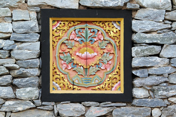 The lotus sculpture on the stone wall.