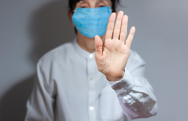 Stop coronavirus quarantine and Air pollution pm2.5 concept. Sick old woman wearing respirator mask for protect with outstretched arm. Wuhan, China epidemic virus symptoms background.