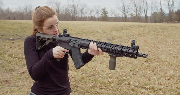 Female fires an automatic rifle in slow motion