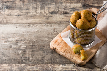 Cod fritters on wooden table copy space	