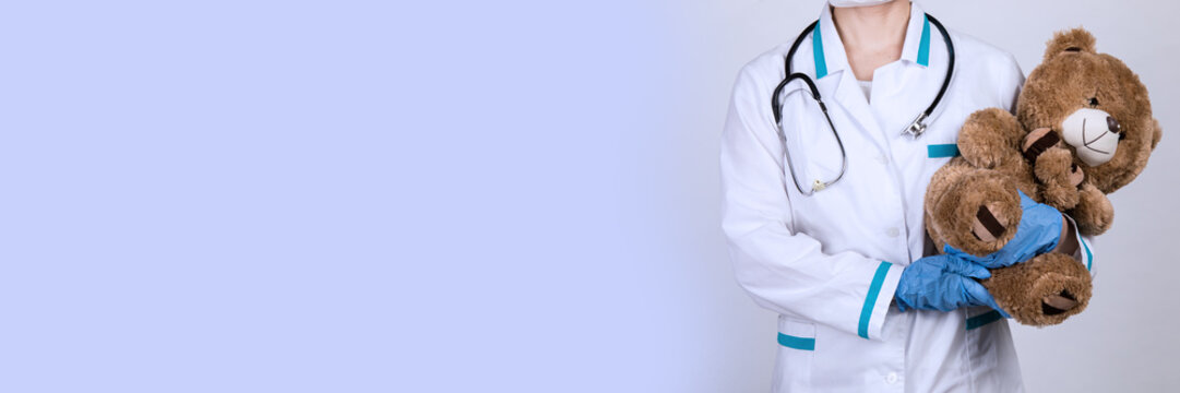 Female doctor pediatrician holding a teddy bear