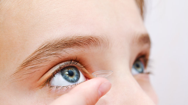 Little Girl Child Putting Contact Lens Into Her Eye