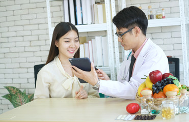 Asian nutritionists are instructions on how to eat a healthy diet to beautiful young women in the office