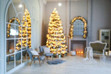 Festive room interior with stylish furniture and beautiful Christmas tree, blurred view