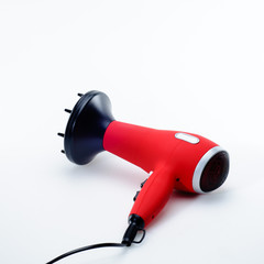 Red hair dryer on the white matt background
