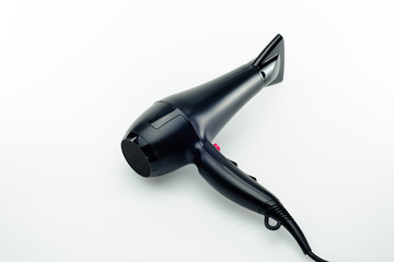 Black hair dryer on the white mirror background