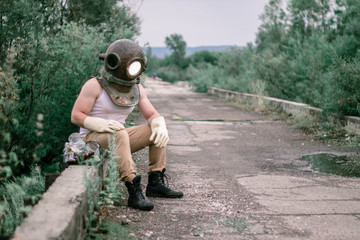 Diver sits on a bridge with a bag of garbage.