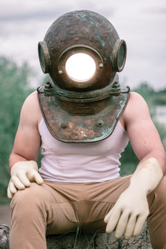 Diver with a spotlight from a helmet shines into the camera.