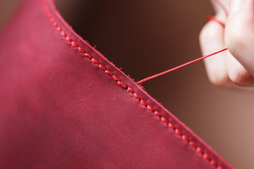Conceptual profession of a Tanner. The woman's hands closed around the needle and thread.