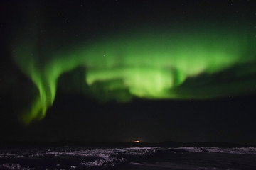 Vivid northern lights over the frozen Nunavik tundra and a truck in the distance(Canada)