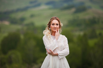 the bride walks in the field against the backdrop of the mountain