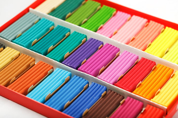Fototapeta premium Plasticine in a box of multi-colored pieces in full screen, material for modeling.