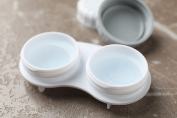 Case for contact lenses on grey background, close up