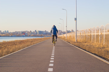 Obraz premium a man rides a bicycle on a cycle track. a bike ride in cold weather.