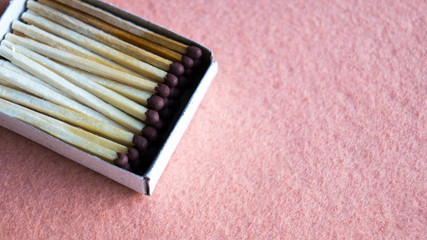 Matches in a cardboard box on a beige background. View from above. Close-up shot. The concept of mining fire, wood, hiking.