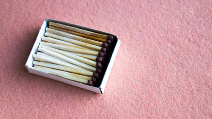 Matches in a cardboard box on a beige background. View from above. Close-up shot. The concept of mining fire, wood, hiking.