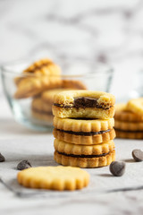 Stack of sandwich cookies with chocolate ganache filling