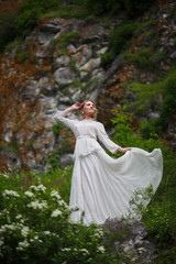 Fototapeta premium the bride walks in the field against the backdrop of the mountain