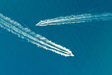 Two motor boats with a Wake behind them on a turquoise background of the sea surface. Shooting from...
