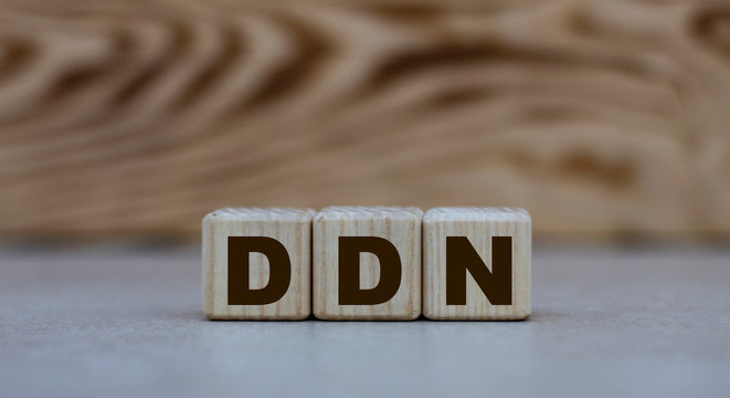 concept word DDN on cubes on a beautiful wooden background