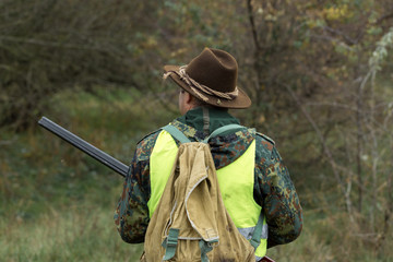 Hunting period, autumn season open. A hunter with a gun in his hands in hunting clothes in the...