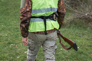 Hunting period, autumn season open. A hunter with a gun in his hands in hunting clothes in the...
