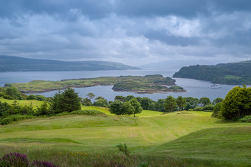 Island of Mull golf fields and sea view with ferry crossing Tobermory bay. Scotland.