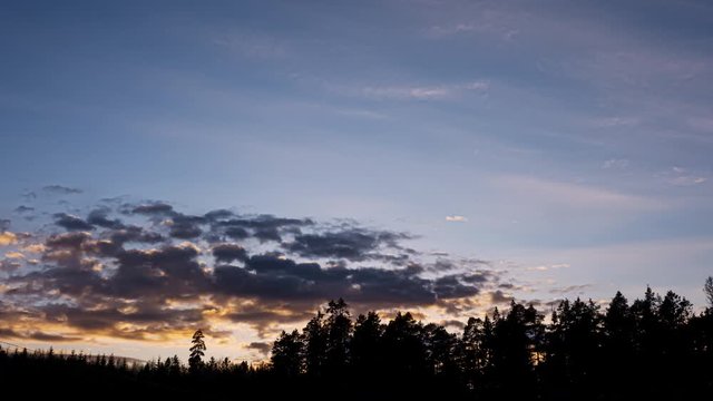 Sunset timelapse of clouds moving in over forest, Birkeland, Norway