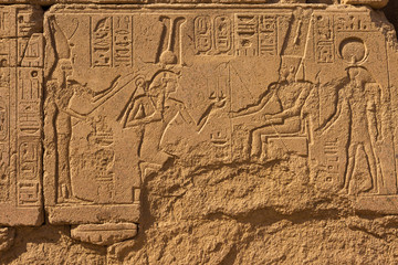 Fototapeta na wymiar Karnak Temple, Colossal sculptures of ancient Egypt in the Nile Valley in Luxor, Embossed hieroglyphs on the wall.