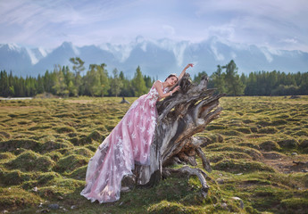 Queen. The girl in the image of a queen on a background of mountains