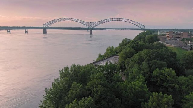 Aerial flying over traffic on the Hernando de Soto Bridge that crosses the Mississippi River at sunset. Memphis, Tennessee, USA
