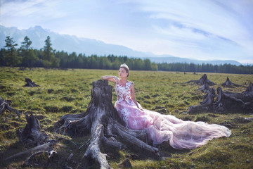 Queen. The girl in the image of a queen on a background of mountains