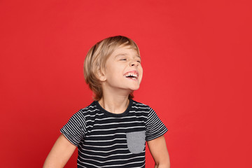 Portrait of happy little boy on red background © New Africa
