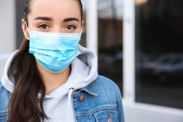 Woman wearing disposable mask outdoors. Dangerous virus