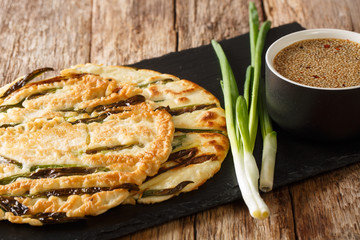 Korean style homemade pancakes with green onions close-up on a slate board. horizontal
