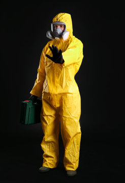 Man in chemical protective suit on black background. Virus research