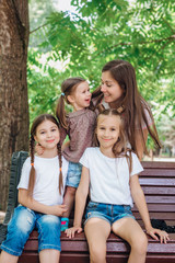 Lifestyle portrait mom and three daughters in happines at the outside in the park